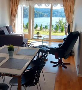 卑尔根Bjørnestrand Fjordside View的客厅配有桌椅和大窗户
