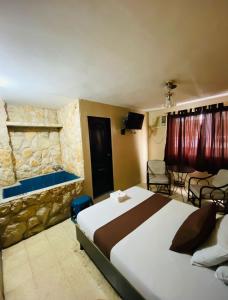 瓜亚基尔Hostal Bellagio的一间卧室设有一张大床和石墙