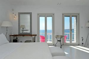 帕罗奇亚卡斯特罗别墅的一间白色的卧室,配有一张床,享有海景