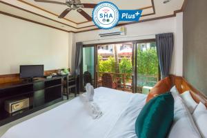 哈林海滩Sunrise Resort- Koh Phangan - SHA Extra Plus的一间卧室配有一张带电视和书桌的床。
