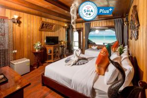 哈林海滩Sunrise Resort- Koh Phangan - SHA Extra Plus的一间卧室设有两张床和一个读书的标志