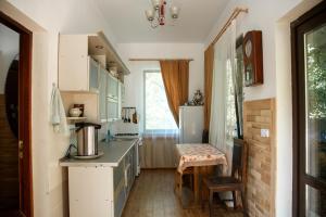 卡缅诺莫斯茨基Guest House Edelveys的厨房配有白色橱柜和桌子