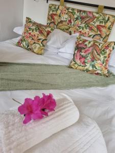 克卢夫Impunzi Place的一张白色的床,上面有粉红色的花
