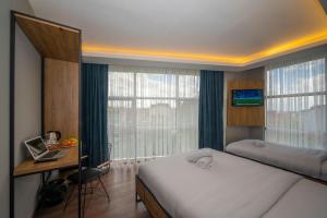 乔尔卢Çorlu Dem Hotel的一间卧室配有一张床、一张书桌和一个窗户。