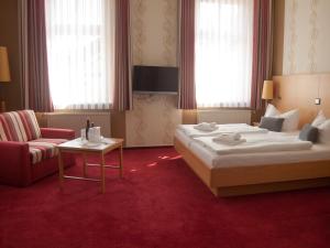 屈里茨Hotel & Restaurant Waldschlösschen的配有一张床和一把椅子的酒店客房