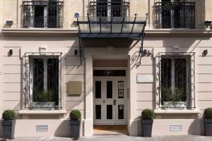 巴黎卢森堡花园酒店的前面有盆栽植物的白色建筑