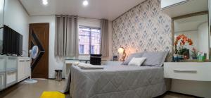 维索萨-杜塞阿拉Flat da Vila的一间带大床和电视的卧室