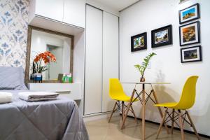 维索萨-杜塞阿拉Flat da Vila的一间卧室配有桌子和两张黄色椅子