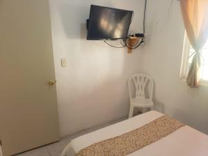 锡瓦塔塔内霍Ixtapa Confort的配有床、椅子和电视的房间