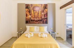 巴勒莫Barlaman Luxury Rooms的卧室配有一张大黄床,墙上挂有绘画作品