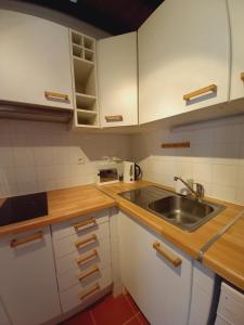 欧里基Solar da Cavalariça的厨房配有白色橱柜和水槽