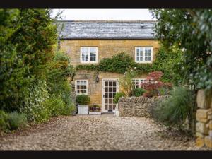 Weston SubedgeWisteria Cottage , Pretty Cotswold Cottage close to Chipping Campden的一座古老的砖房,有石头车道