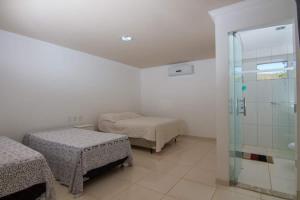 里奥迪孔塔斯Pouso da Soraya的一间卧室设有两张床和玻璃淋浴间