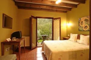 索托德坎加斯La Ablaneda的一间卧室配有一张床、一张书桌和一个窗户。