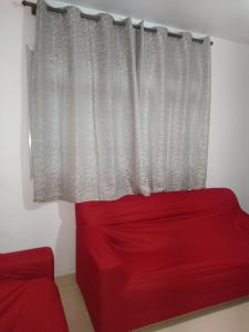 大普拉亚Apartamento Boqueirao的窗前的红色沙发