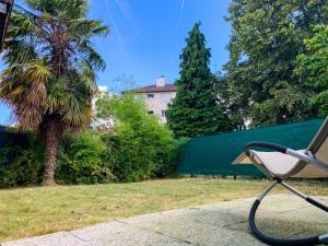 奥尔日河畔布雷蒂尼Joli studio avec jardin - Gare RER C -proche PARIS的棕榈树旁人行道旁的公园长凳