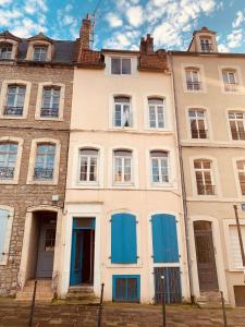 滨海布洛涅Le cottages des remparts - le lodge的一座古老的建筑,设有蓝色的门窗