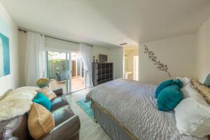 卡尔斯巴德海滩步道别墅的一间卧室配有一张床和一张沙发