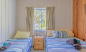 彭特派因Anson Bay Lodge的一间卧室设有两张床和窗户。