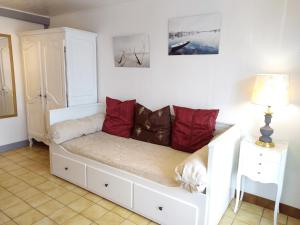 布雷斯地区布尔格Brou-seillon : entre histoire et nature的客房内的白色沙发上配有红色枕头