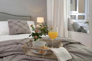 马拉加Living4Malaga Soho Orangerie Deluxe的床上一篮子的食物和一杯橙汁