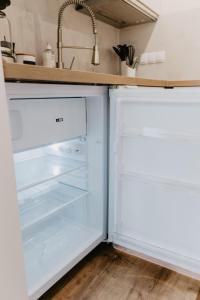 盖尔森基兴SK Apartments - Sandwood的厨房里设有白色冰箱,门开