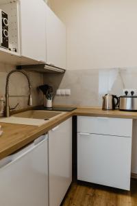 盖尔森基兴SK Apartments - Sandwood的厨房配有白色橱柜和水槽