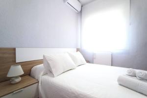 托莱多Lux Buenavista的卧室配有白色的床和窗户。