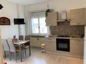 卡萨莱蒙费拉托"L'Armonia" Apartment的厨房配有桌子和炉灶。 顶部烤箱
