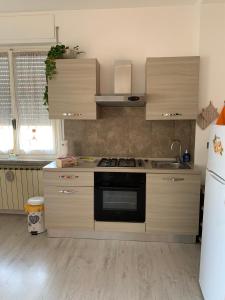 卡萨莱蒙费拉托"L'Armonia" Apartment的厨房配有炉灶和冰箱。
