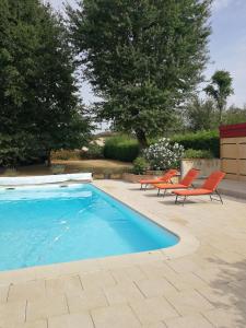 Lucbardez-et-BarguesAu Doux Repos的游泳池旁配有两把橙色椅子