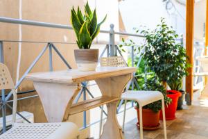 斯基亚索斯镇Aura Skiathos的植物阳台的桌椅