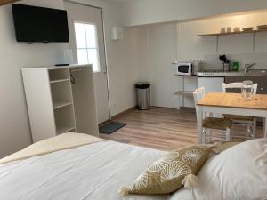 贝叶Appart’hôtel saint patrice的一间卧室配有一张床铺和一张桌子,还设有一间厨房