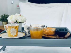 Sere KundaMica Apartments的盘子,盘子上放着两杯橙汁和一盘食物