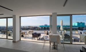 比比翁HVB 34 Lifestyle 4 Superior的庭院设有桌椅和玻璃窗。