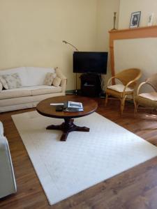 SaulgondLa Poste Saulgond的客厅配有咖啡桌和白色地毯。