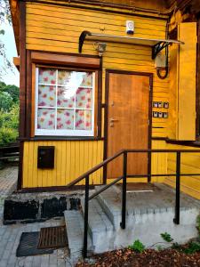 考纳斯RailWay Bed HOSTEL的黄色的房子,有门和窗户