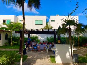 坎昆Boutique House Cancun by Elevate Rooms的坐在院子里桌子上的一群人