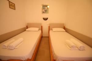 萨尔蒂SARTI CENTER studios的小客房内的两张床和毛巾