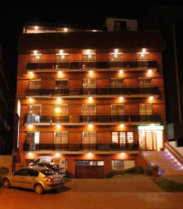 马德普拉塔家庭公寓式酒店的一座建筑,晚上停在前面