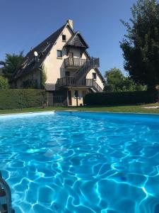 多维尔Résidence le Manoir du Mont Canisy Piscine & Tennis的一座房子前面设有游泳池