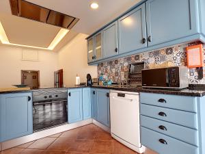雷根古什-迪蒙萨拉什Casa Refugio Do Campo的一间设有蓝色橱柜和电器的大厨房