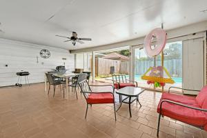 休斯顿Home for summer with pool, pool table, outdoor kitchen,patio and balcony的客厅配有红色椅子和桌子