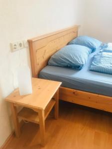 施卢赫湖Sporthostel Rössle的一张带蓝色枕头的床,坐在桌子旁