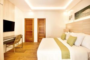 长滩岛Kaaya Resort North Boracay的酒店客房配有床、书桌和台面