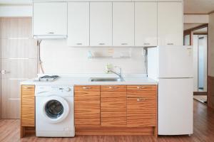 西归浦市君姆海桑帕克特尔度假屋的厨房配有白色冰箱和洗衣机。
