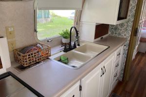 博福特Amazing Airstream, Beaufort, SC-Enjoy the Journey的带水槽的厨房台面和窗户