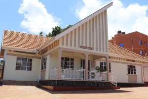 坎帕拉Luwafu Guest House的街道上带阳台的白色房屋