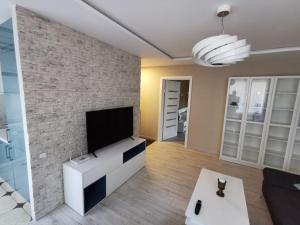 卢扎ALDO comfort的一间客厅,在砖墙上配有平面电视