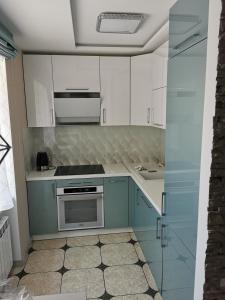 卢扎ALDO comfort的厨房配有白色橱柜和炉灶。